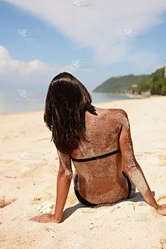 放松的漂亮女人坐在海滩上
