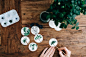 A person painting plants on small white stickers