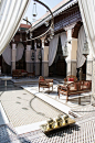 The beautiful Moroccan central courtyard with fountain and wooden garden furniture at the Royal Mansour hotel, Marrakech, Morocco: