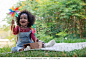 Dark skinned little girl blowing windmill, cute little girl holding colorful toy pinwheels on summer day