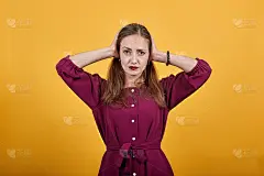 女士在孤立的橙色背景沮丧和捂耳朵