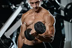 英俊的模特年轻男子在健身房训练手臂