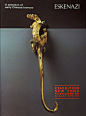 This may contain: an ornate gold hook on the wall in front of a black background with red lettering