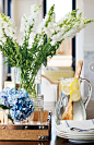 白色的金鱼草，绣球花，柠檬水的透明玻璃壶。 尼斯组成。