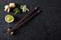 Chopsticks and food ingredients on black stone table top view by Kamil Zabłocki