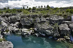瀑布流过岩石，流入清澈的山间河流
