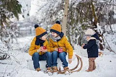 可爱的兄弟姐妹们，孩子们在雪地里开冬季派对。年轻的兄弟们，男孩子们，用保温瓶喝茶。热饮和冷饮