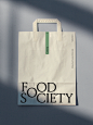 This may contain: a paper bag with the word food society printed on it