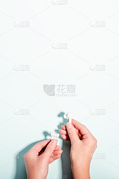 白色无线耳机在女性的手在柔和的背景，复制空间。现代科技平躺与无绳耳机在女性手中，现代生活理念