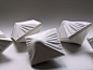 This may contain: four white folded objects sitting on top of a table