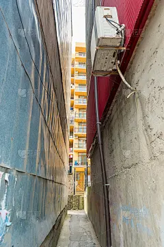房子之间狭窄的通道，可以看到带阳台的房子
