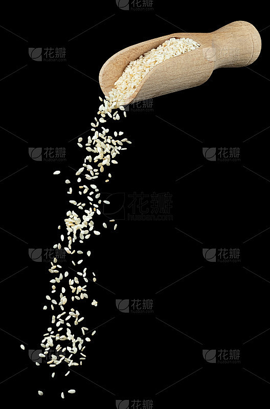 芝麻籽从木勺孤立落下