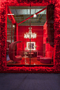 a red room with a chandelier and two chairs in the center, surrounded by fake fur