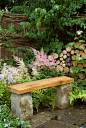 在后院花园庭院的石头和木凳，有花，|  植物＆花卉图库摄影：GardenPhotos.com