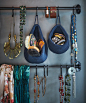 Jewellery and accessories hanging from rails on a blue wall.