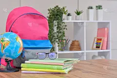 书包、学习用品放在学校教室的背景上。回到学校和幼儿园。开学季的开始。