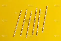 明亮的纸吸管的鸡尾酒黄色背景与拷贝空间。暑假的概念。简约风格的平铺。