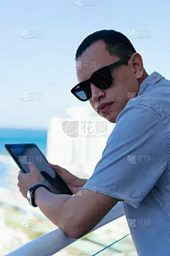 一个拉丁人站在家里的长凳上研究他的平板电脑