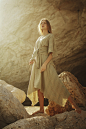 woman in brown dress standing on rock