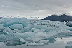 Jokulsarlon冰川泻湖和山脉与飞鸟的背景