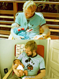 第一张图：一位29岁的父亲抱着两周大的儿子；第二张图：儿子29岁时，穿着当年父亲穿的旧t恤，抱着自己两周大的孩子。