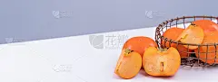 新鲜漂亮的甜柿子片孤立在白色餐桌上以灰蓝色为背景，中国农历新年的设计理念。