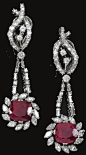 Pair of ruby and diamond pendent earrings, 1950s.   Each stylised ribbon surmount set with brilliant- and single-cut diamonds, suspending a cushion-shaped ruby within a surround of marquise-shaped diamonds, to articulated lines of baguette and single-cut 
