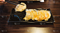 手捏烧饺(日式煎饺)装在黑色的盘子里。