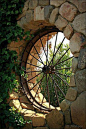 Old wagon wheel as window feature in garden: 
