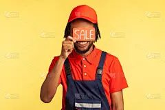 无名男工人站在那里，捂着眼睛，手里拿着印有销售铭文的名片，服务行业。