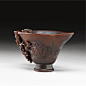 A carved rhinoceros horn 'prunus' libation cup, Qing Dynasty, 18th-19th century