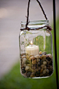 Mason jar hanging candle holders.  Use sand instead of pebbles.  Some jars can be coated with glass paint to match colored bottles.  12 quart size jars are about 11.00.  Suggest different sizes.  Small jelly jars are "quilted" creating a faceted