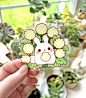 Tanpopo Puddle Bunny Vinyl Sticker : Small as a dandelion puff, this wee puddle bunny nestles in the soft leaves of a weedy patch. These vinyl stickers are a fun way to decorate anything from stationery items like notebooks and planners to household items