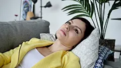 放松的年轻女子躺在家里的沙发上