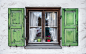 Authentic window with green wooden shuttters in a small town of