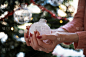 女性的手与红色的节日美甲拿着闪亮的白色圣诞小玩意