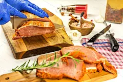 屠夫在厨房的木板上切猪肉。厨房用具。准备烤肉。家乡菜。