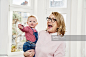 Happy grandmother carrying baby girl at home : Stock Photo