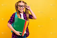 近距离的照片，小女士小学生手持抄本，漂亮的马尾辫，穿眼镜格子衬衫孤立的黄色背景