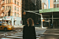 woman in black coat standing on pedestrian lane during daytime
