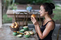 年轻女人享受早餐和手拿羊角面包。早上好心情