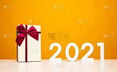 圣诞快乐，新年快乐2021白色桌子和黄色背景与礼物盒模型。庆祝与新年模板和空白背景广告。