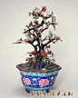 碧玺桃树盆景，清中期，苏州造，通高56cm，盆高16.5cm，口径31.2cm。

　　画珐琅菱花式盆，盆外壁以深、浅蓝色釉为地，彩绘牡丹花纹。盆中植桃树为主景，木枝干，碧玉叶，桃实以芙蓉石、碧玺、蜜蜡等红、粉色宝石制作。树下衬以湖石、山茶、锦花一周。此景错落有致，意态生动，表现出清爽明丽的江南盆景风格。

　　此件盆景是宫中日常陈设品，桃树景配牡丹花纹盆取“蟠桃献瑞”、“富贵长寿”之意，应是皇帝寿诞之日百官祝寿所进献之物。

