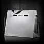 Newly redesigned DKNY shopping bag cinches closed with a pull of the ribbons, creating an interactive experience for the consumer.