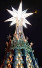 This may contain: a very large star on top of a building with many lights in the night sky