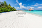 Wide sandy beach on a tropical island in Maldives. Palms and wat