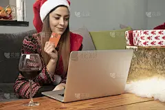 年轻的微笑美丽的女孩喝酒和使用信用卡