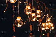 一个美丽的创意玻璃球花环内燃烧的灯泡在黑暗的背景。圣诞和新年的喜庆背景。