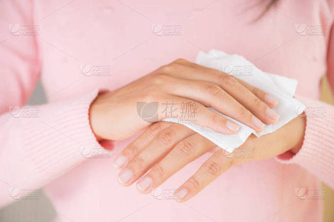 女人用纸巾擦手。医疗保健理念.