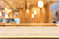 木质桌子与抽象模糊的咖啡馆餐厅与散焦灯光背景